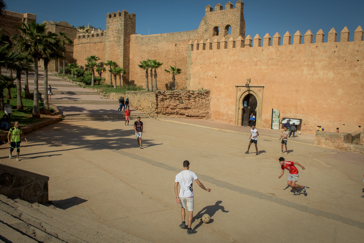 Locals play soccer just outside ancient city walls.